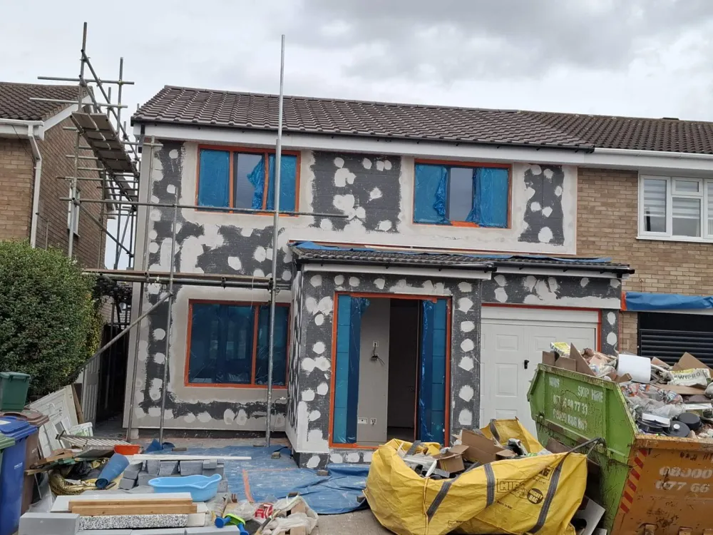 Applying render basecoat and fibreglass mesh over insulation boards in London