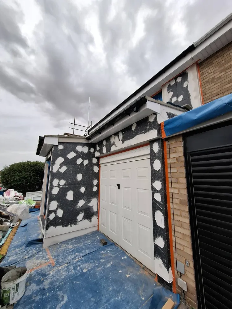 Reinforced render basecoat with insulation fixings on a London house